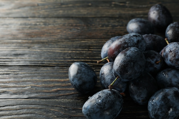 Prunes fraîches sur table en bois se bouchent