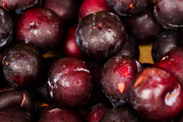 Prunes fraîches en tas au marché fermier local.