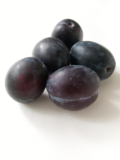 prunes juteuses mûres sur fond blanc