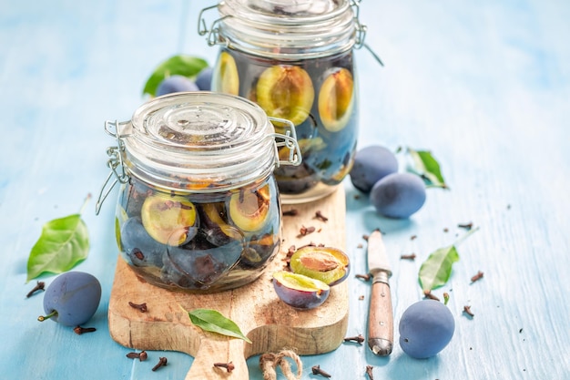 Prunes marinées maison et saines au vinaigre avec des clous de girofle