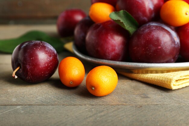 Prunes mûres dans une plaque de métal sur une table en bois agrandi