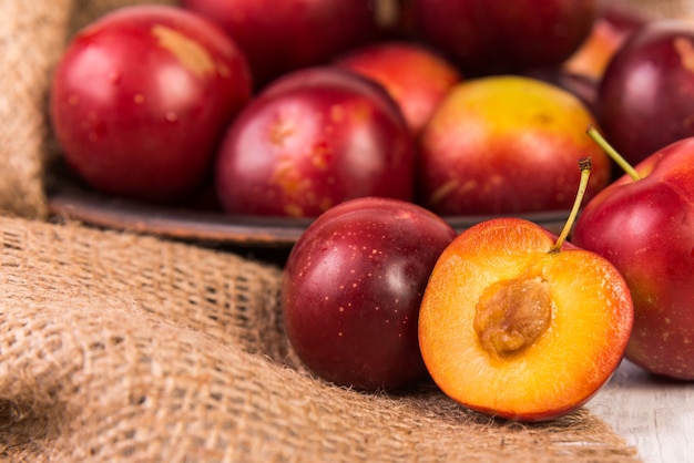 Prunes rouges mûres sur sac de jute