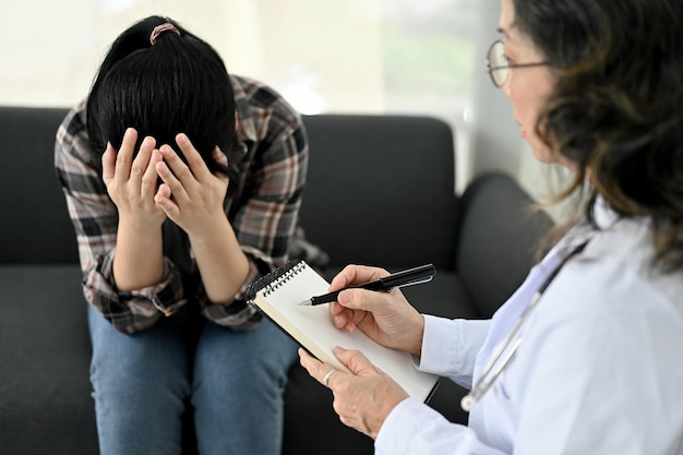 Psychiatre ou psychologue professionnelle d'âge asiatique parlant et diagnostiquant une patiente