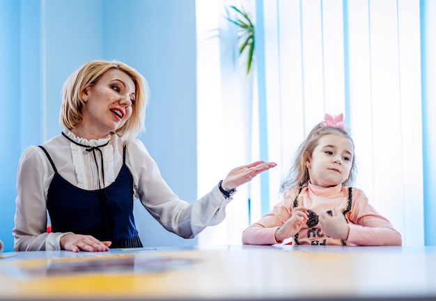 Psychologue féminine avec une jolie petite fille pendant la thérapie par le jeu