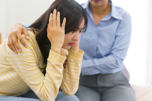 Psychologue féminine réconfortant et encourageant une patiente stressée tout en écoutant son problème au bureau