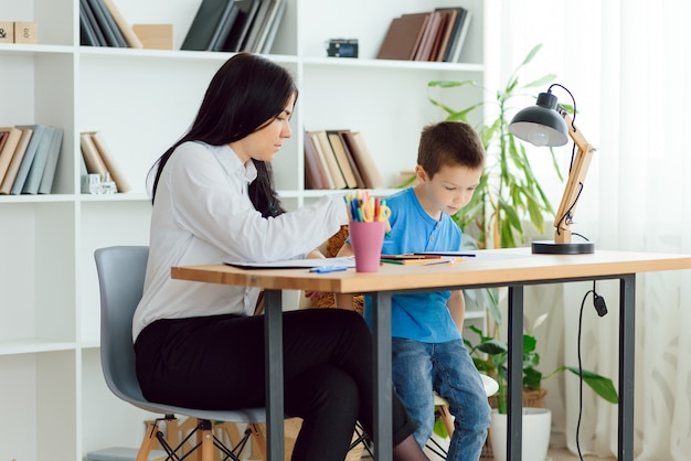 Psychologue pour enfants travaillant avec un garçon au bureau