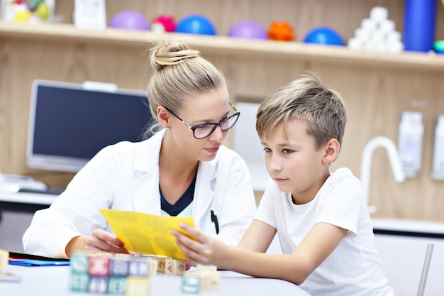 psychologue pour enfants travaillant avec un jeune garçon au bureau