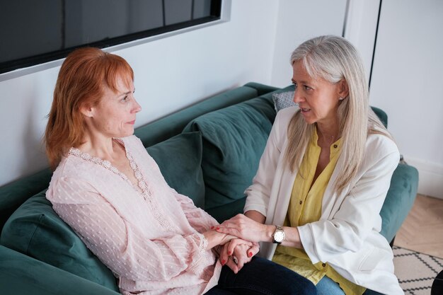 Psychologue réconfortant son patient avec différents traumas et pleurs dans son bureau Concept de tristesse