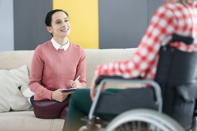 Psychologue travaillant avec un patient en fauteuil roulant dans un centre de réadaptation