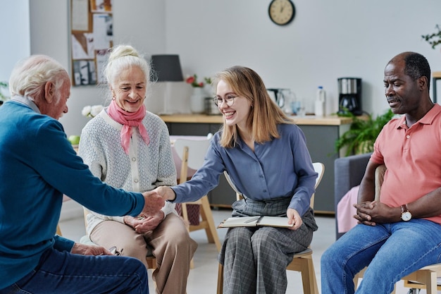 Psychothérapeute saluant les personnes âgées en thérapie