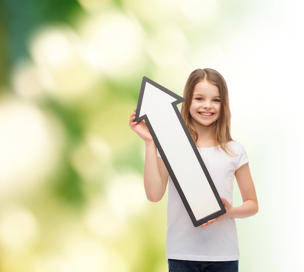 publicité et concept d'enfant - petite fille souriante avec une flèche vide pointant vers le haut