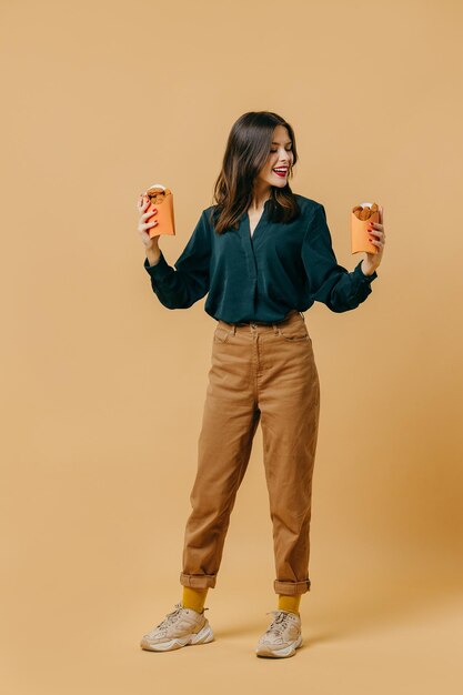 Publicité conceptuelle de restauration rapide Une fille avec un hamburger sur fond coloré Art contemporain