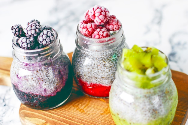 Pudding au chia avec baies, sauce à la framboise, sauce au kiwi, sauce à la mûre et framboises surgelées