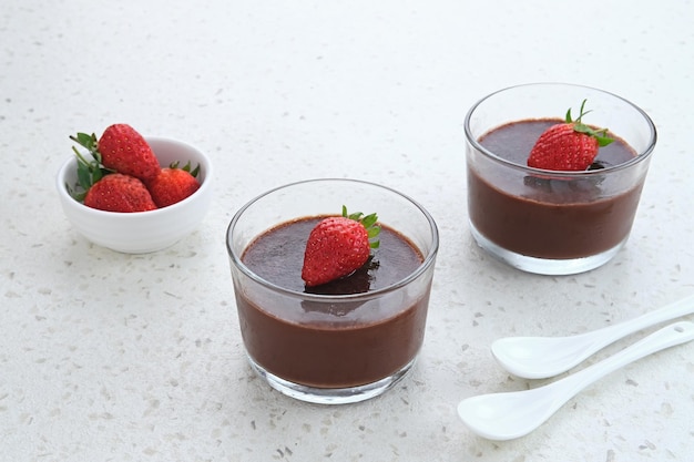 Pudding au chocolat avec des fraises en verre sur tableau blanc Mise au point sélectionnée