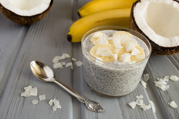 Pudding au lait de coco, cchia et banane sur le bois gris