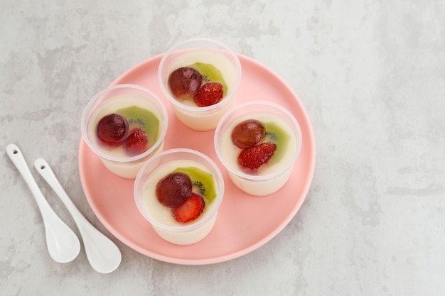 Pudding au lait fruité, doux dessert au pudding de soie à la vanille avec fraise, raisin et kiwi