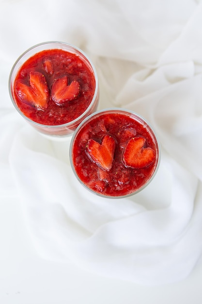 Pudding aux fraises et graines de chia dans une tasse pour le petit-déjeuner et fraises en forme de cœur. 14 février, jour de la Saint-Valentin.