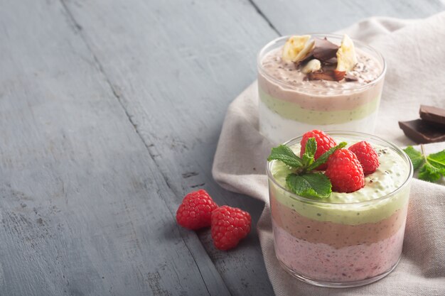 Pudding aux graines de chia aux trois saveurs, cacao, matcha et fraise avec yaourt, chocolat et feuilles de menthe. Espace copie