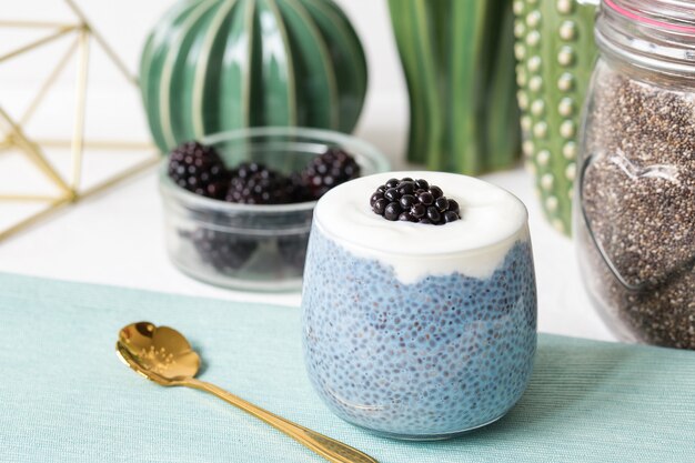 Pudding aux graines de chia bleu avec des mûres dans un verre