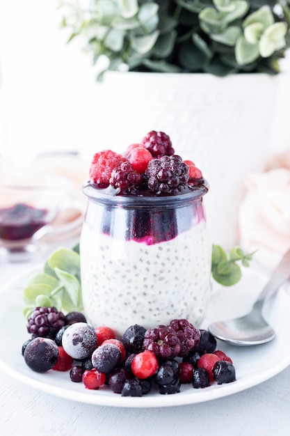 Pudding de chia avec confiture de fruits rouges au yogourt à la noix de coco et fruits frais surgelés