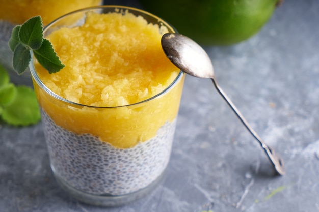 Pudding de chia à la mangue et à la menthe en verre sur tableau gris