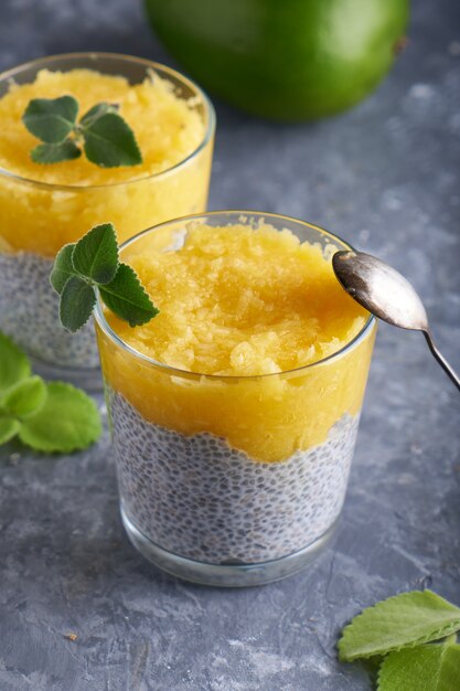 Pudding de chia à la mangue et à la menthe en verre sur tableau gris