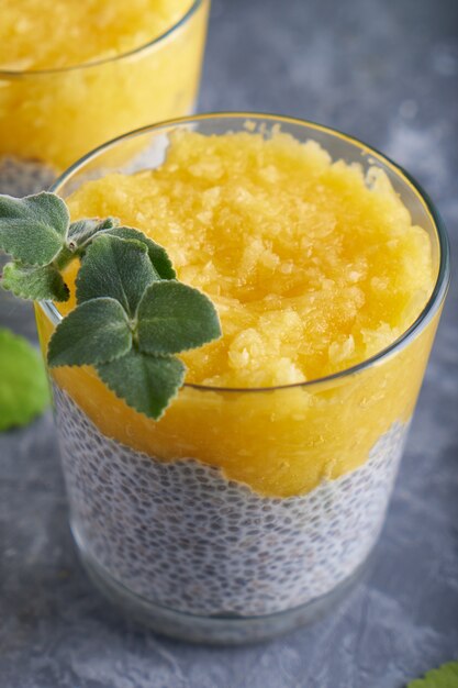 Pudding de chia à la mangue et à la menthe en verre sur tableau gris