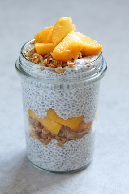 Pudding de chia avec des tranches de pêche et de mangue dans un pot