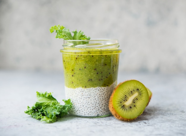 Pudding de chia végétarien dans un bocal avec du lait de coco et du kiwi, mise au point sélective, aliments crus purs, espace de copie