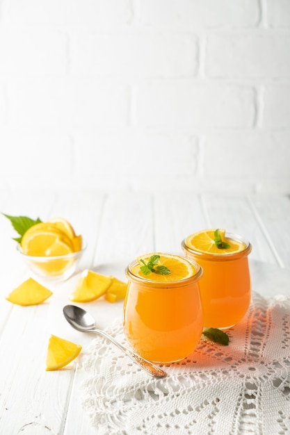 Pudding à la gelée dessert sucré aux agrumes orange dans un bocal en verre sur fond blanc