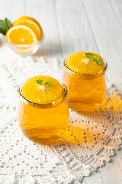 Pudding à la gelée dessert sucré aux agrumes orange dans un bocal en verre sur fond blanc