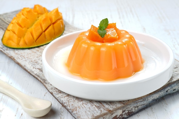 Pudding de mangue, gelée, dessert sur plaque blanche.sur fond blanc