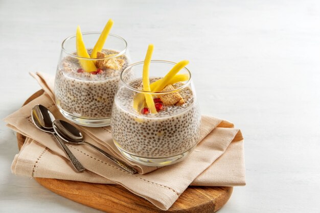 Pudding de noix de coco chia végétalien à la mangue sur fond blanc. Nutrition saine, superaliments. Vue rapprochée.