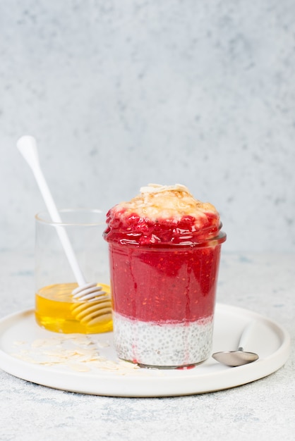 Pudding végétalien au chia avec des baies et du lait sur un fond de béton