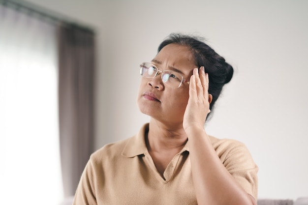 Épuisé, fatigué, déprimé, stressé, mûr, réfléchi, femme âgée souffrant de maux de tête, de maladies du cerveau, de problèmes mentaux, d'Alzheimer Concept.