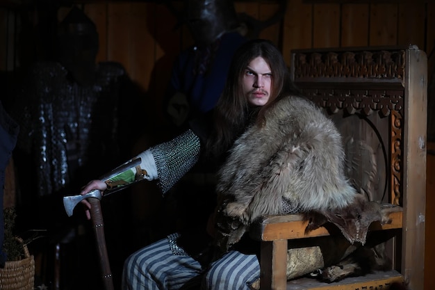 Un puissant héros aux cheveux longs en cotte de mailles dans une ancienne salle Guerrier médiéval