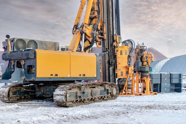 Une puissante foreuse pour empiler en hiver sur un chantier de construction. Exploitation de la plate-forme de forage dans des conditions nordiques. Fondations sur pieux. Pieux forés. Fermer.