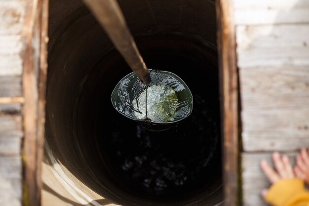 Puits d'eau à l'intérieur d'un puits bleu. Un puits d'eau avec un vieux seau en fer