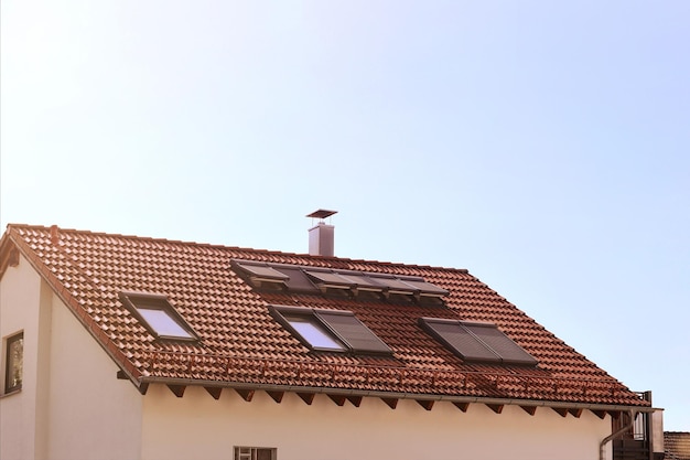 Photo puits de lumière fenêtres mansardées avec volets ou volets roulants sur les fenêtres de toit maison. grenier de lucarne moderne