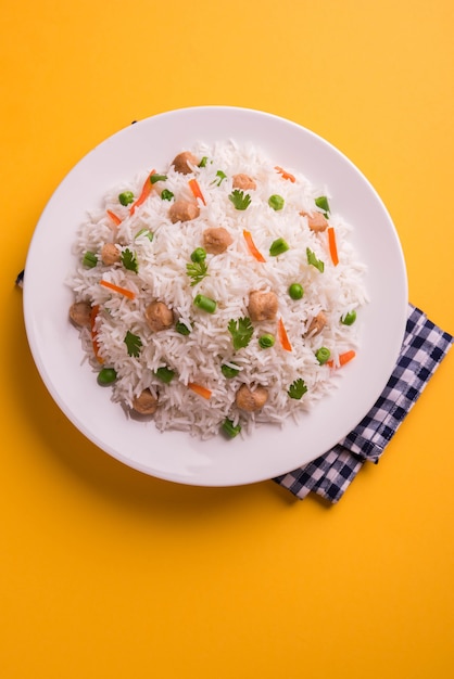 Pulao de soja nutritif ou pilaf ou riz frit en morceaux de soja avec des pois verts et des haricots. Servi dans un bol sur fond coloré ou en bois. Mise au point sélective