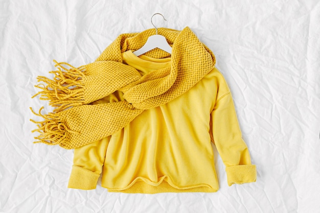 Pull jaune avec écharpe tricotée. Collage de vêtements de mode automne sur fond blanc. Vue de dessus à plat.