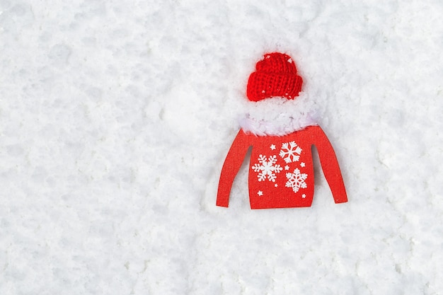 Pull jouet rouge en bois et petit bonnet rouge sur la neige