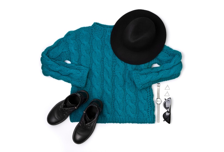 Photo pull plat turquoise vue de dessus, bottes, lunettes de soleil, montre et chapeau