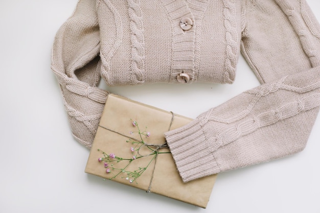 Pull en tricot beige et cadeau en vue de dessus en papier kraft