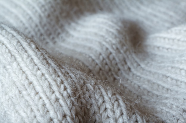 Pull en tricot de couleur grise extrêmement rapproché en laine naturelle, plis ondulés