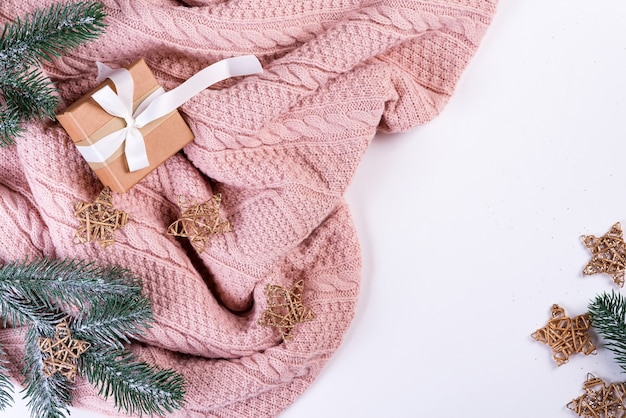 Pull en tricot rose avec boîte-cadeau, décoration de Noël et branches de sapin, vue de dessus. Noël encore la vie