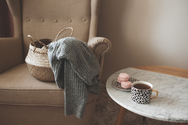 Pull tricoté dans un panier de paille à la maison