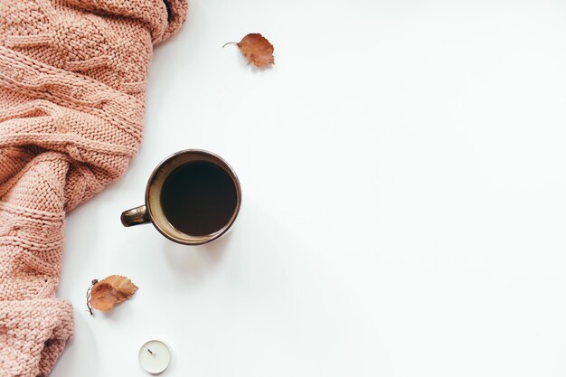 Pull tricoté, tasse de café, feuilles d'automne, bougies sur fond blanc. Composition d'automne. Mise à plat, vue de dessus, espace copie