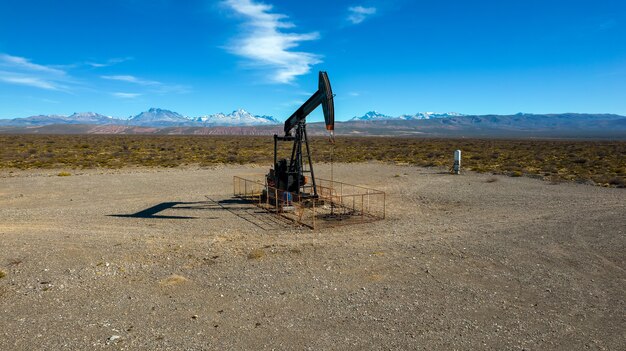 Pumpjack extrayant de l'huile avec un fond montagneux