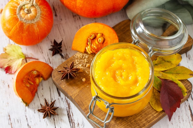 Purée de citrouille aux épices et citrouille sur une table en bois